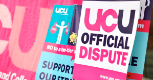 Photograph of stacked posters: "UCU Official Dispute"; "Support our Strikers", "UCU", "NO to a two-tier system"